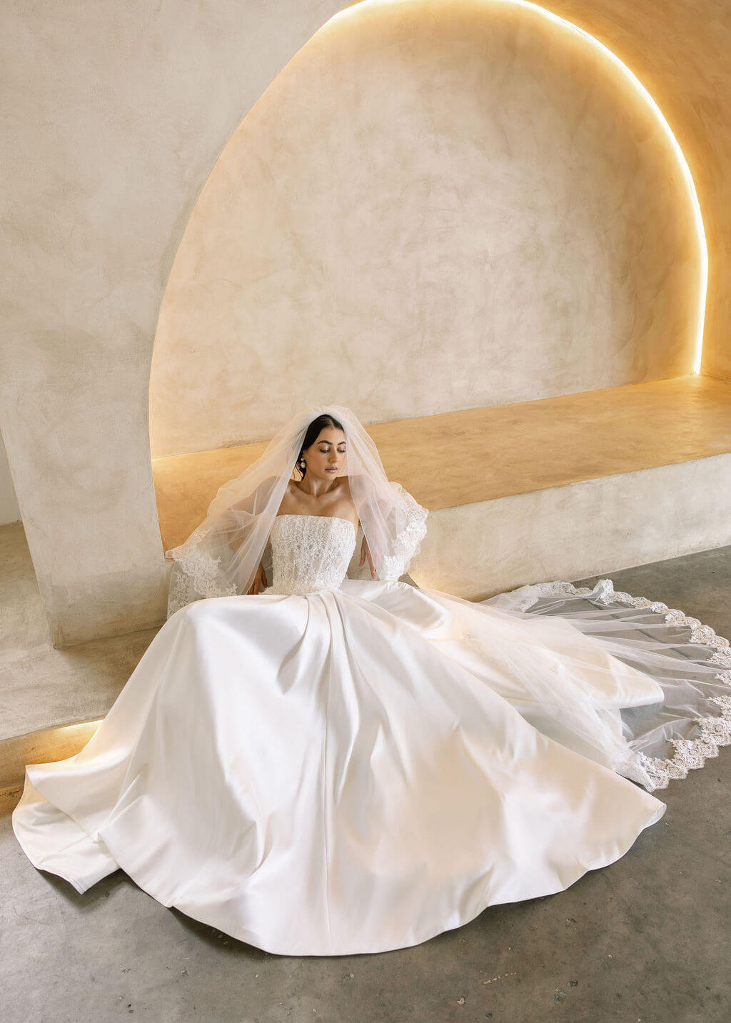 Bride wearing the Viena satin A-line wedding dress with lace corset bodice and flowing skirt.
