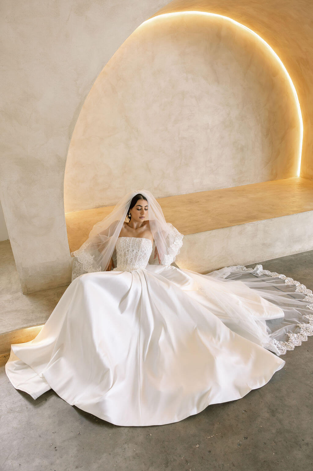 Bride wearing the Viena satin A-line wedding dress with lace corset bodice and flowing skirt.