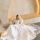 Bride wearing the Viena satin A-line wedding dress with lace corset bodice and flowing skirt.
