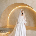 Bride wearing the Viena satin A-line wedding dress with lace corset bodice and long lace veil.