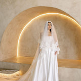 Bride wearing the Viena satin A-line wedding dress with lace corset bodice and long lace veil.