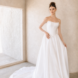 Woman wearing a modern mikado wedding dress in a minimalistic room.