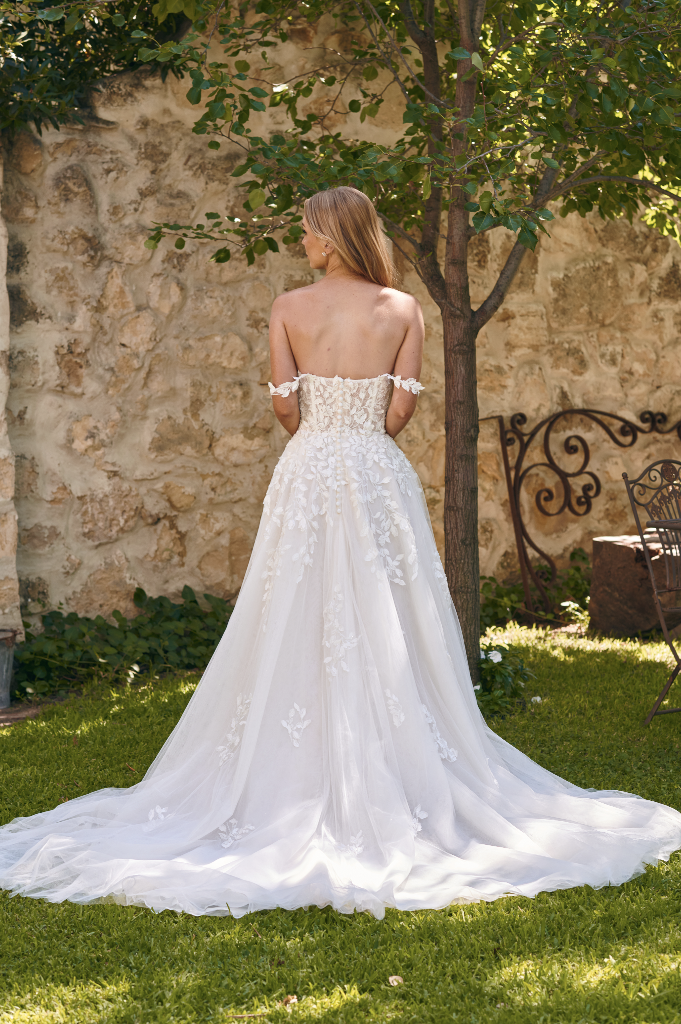 Back view of the Winona boho tulle A-line wedding dress with beaded bodice and flowing layered skirt.
