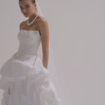 A bride wearing a strapless matte satin bubble wedding dress