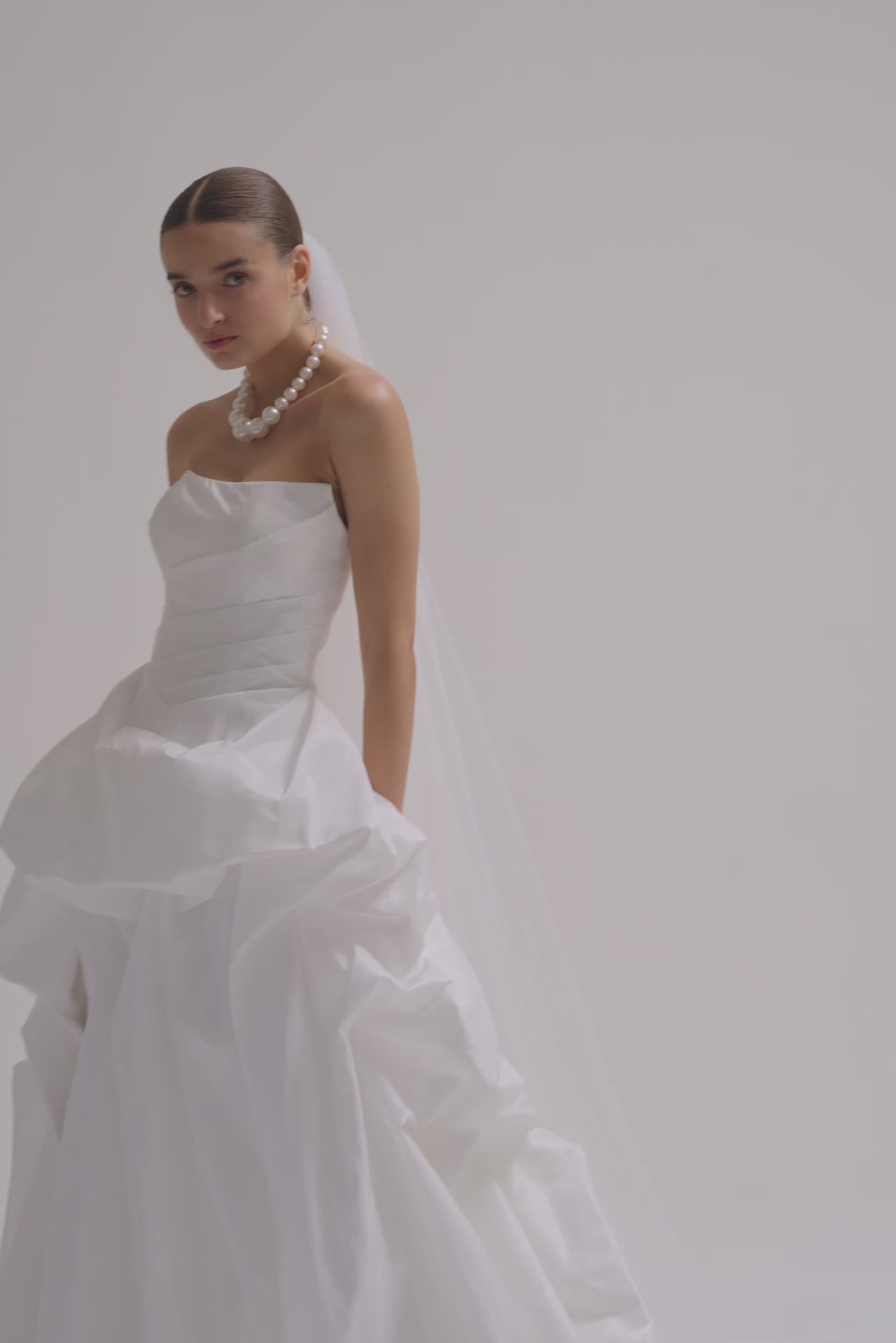 A bride wearing a strapless matte satin bubble wedding dress