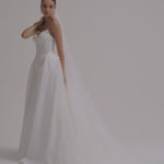 A bride wearing a strapless Duchess satin fitted wedding dress.